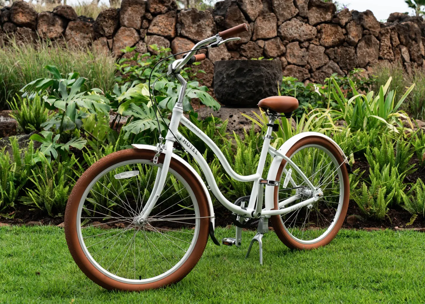 White cruiser bicycle on a lawn and garden path at 1 Hotel Hanalei Bay.