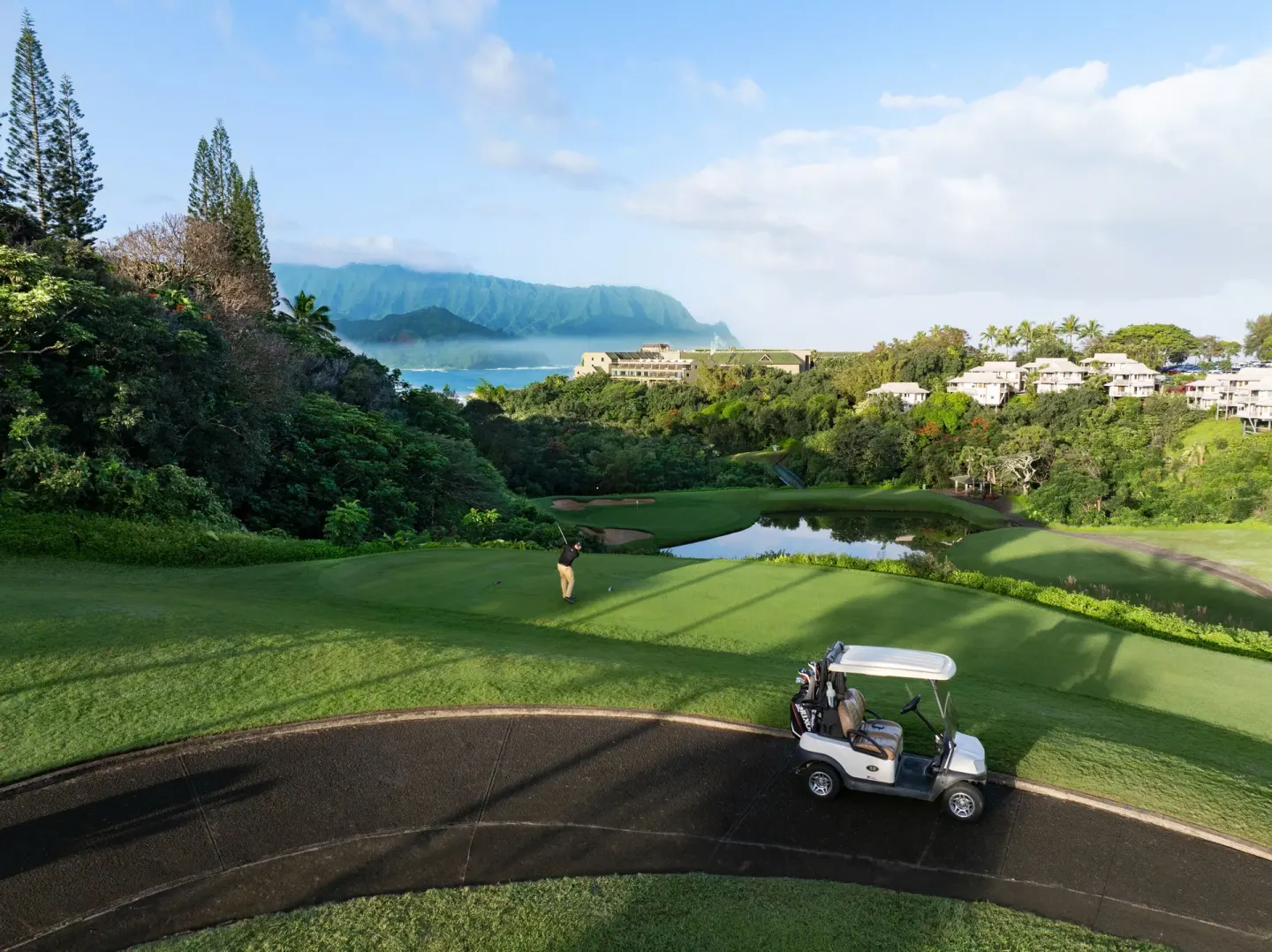 Golf course fairway with cart, pond, and mountain views near 1 Hotel Hanalei Bay.