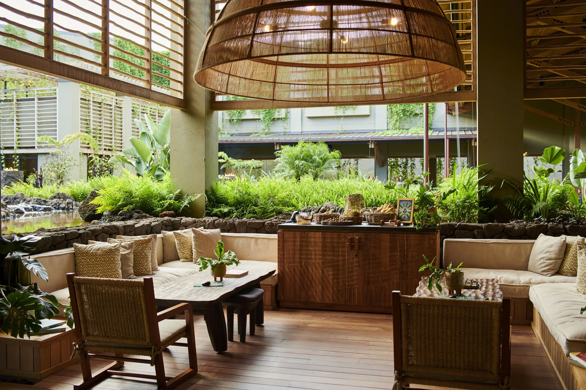 Lobby lounge seating with garden views and woven pendant light at 1 Hotel Hanalei Bay.