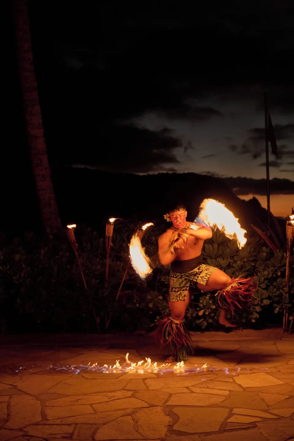Fire dancer performing at night on the grounds of 1 Hotel Hanalei Bay.