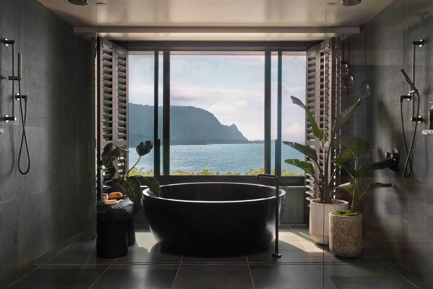 Bathroom with black soaking tub, showers and ocean view at 1 Hotel Hanalei Bay.