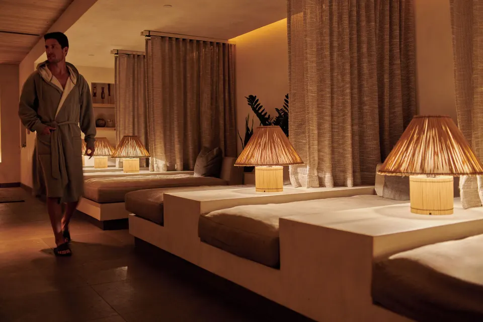 Warmly lit spa relaxation lounge with cushioned daybeds at 1 Hotel Hanalei Bay.