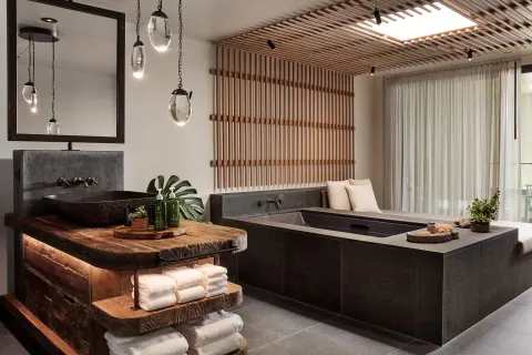 Spa-style bathroom with soaking tub and wood vanity at 1 Hotel Hanalei Bay.