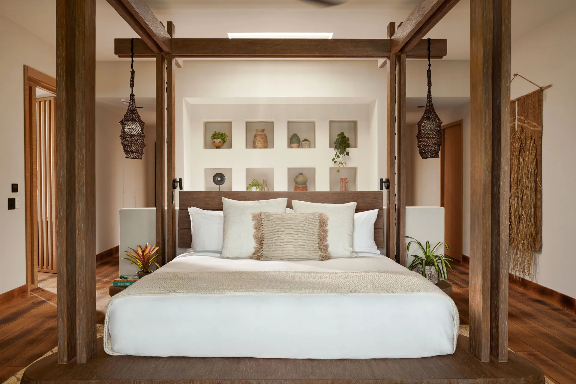 Makana Penthouse canopy bed with wall niches and woven pendants at 1 Hotel Hanalei Bay.