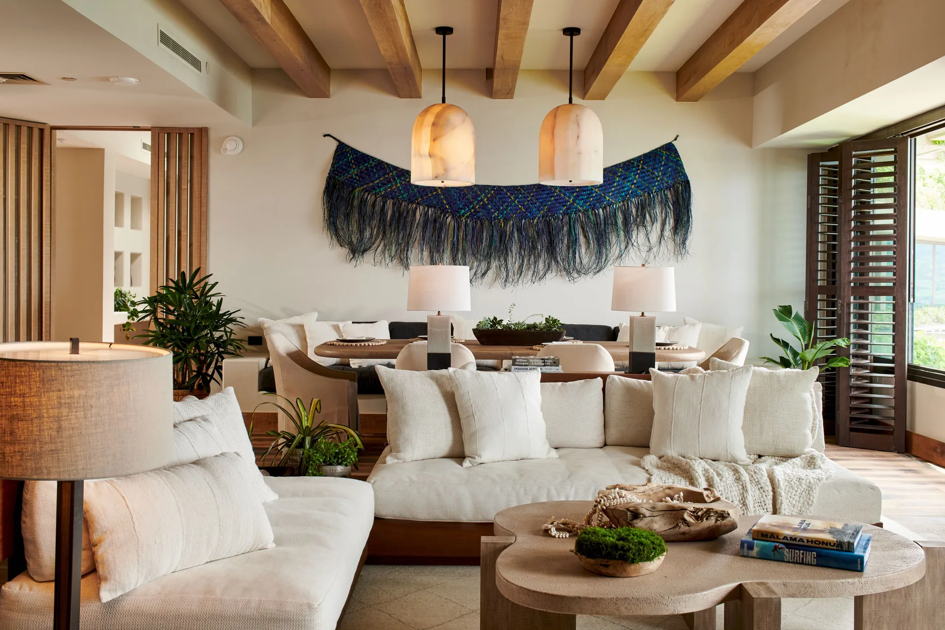Makana Penthouse living room with white sofas and dining area at 1 Hotel Hanalei Bay.