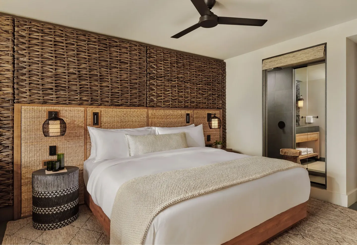 Mountain View king bed guest room with woven headboard and bathroom at 1 Hotel Hanalei Bay.