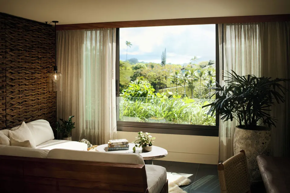 Mountain View guest room sitting area with large window and greenery at 1 Hotel Hanalei Bay.