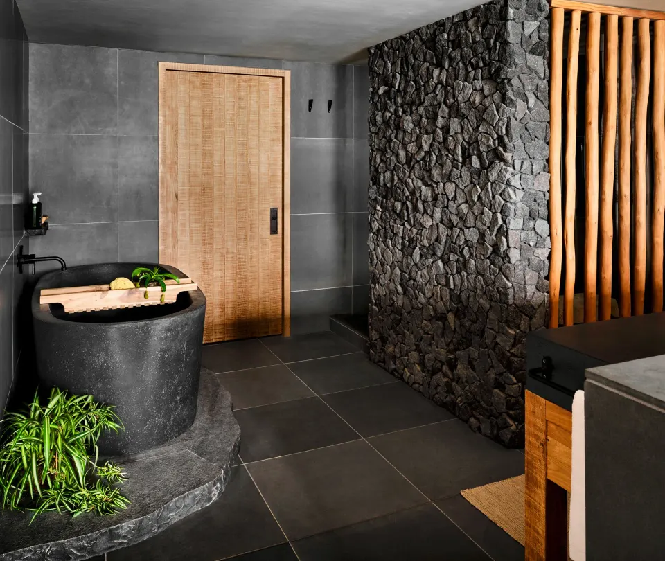 Ocean View 1 Bedroom Suite bathroom with stone tub and rock wall at 1 Hotel Hanalei Bay.