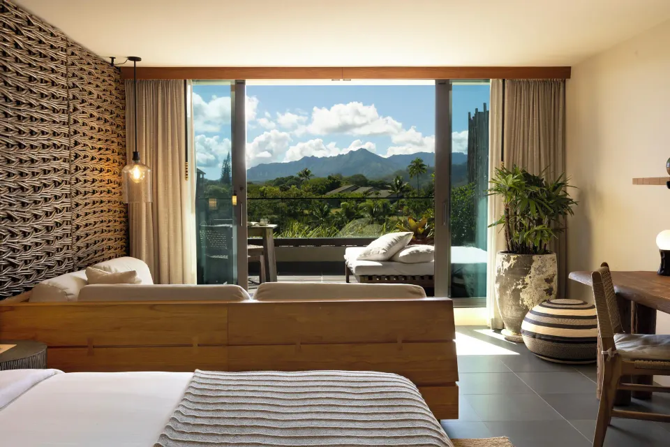 Ocean View 1 Bedroom Suite king bed facing a balcony and mountains at 1 Hotel Hanalei Bay.