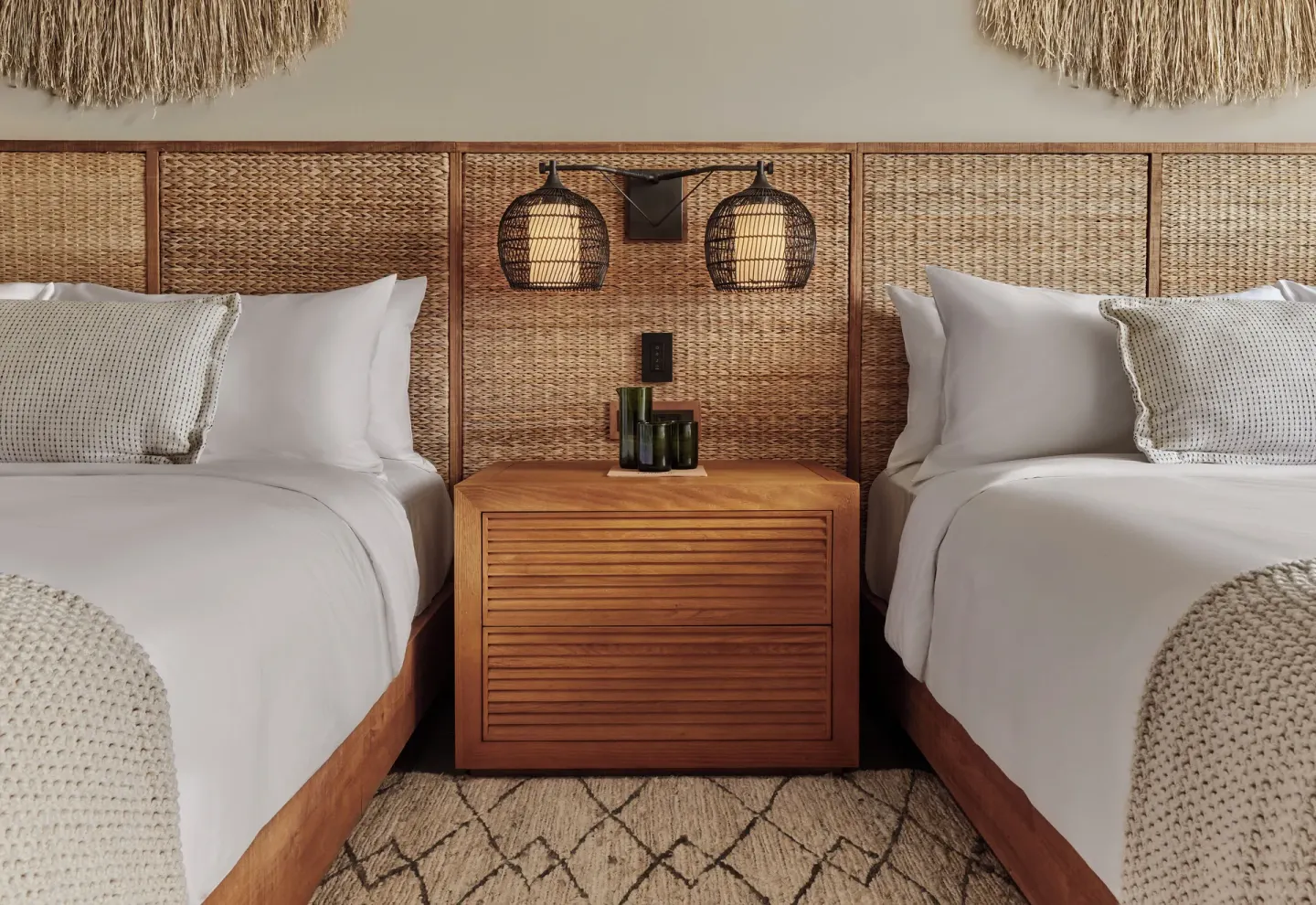 Two double beds with woven headboards in a Pool View Terrace room at 1 Hotel Hanalei Bay.