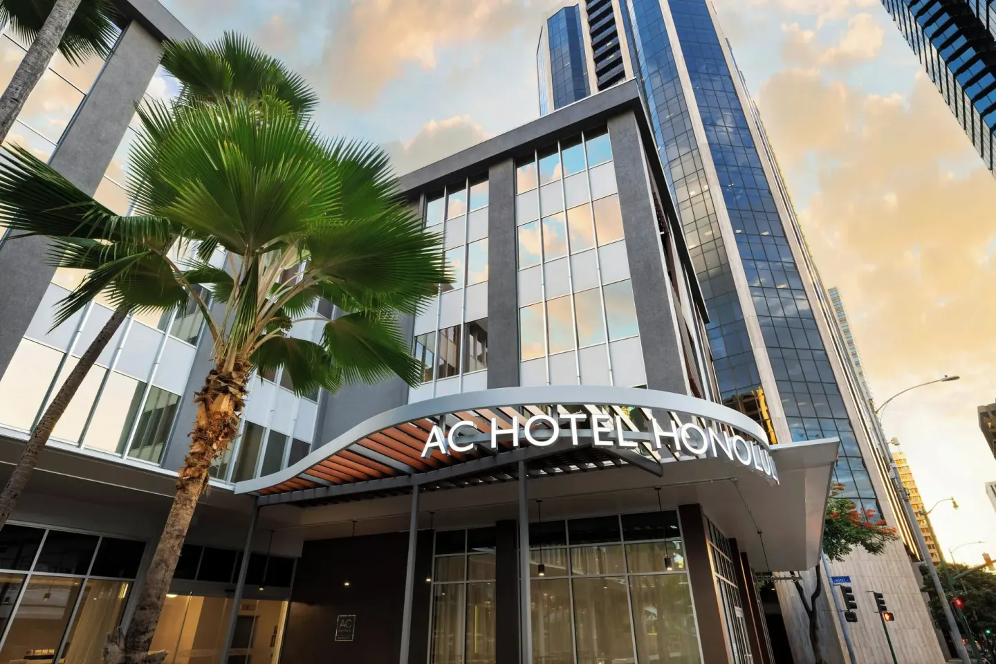 Street-level entrance canopy and palm tree at AC Hotel Honolulu.