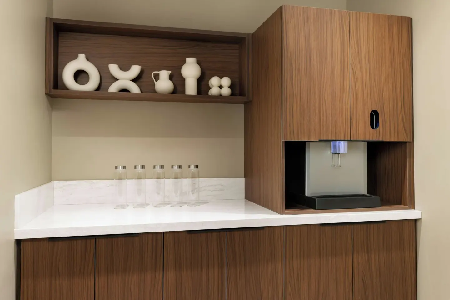 Hydration station with bottles, wood cabinetry and decorative ceramics at AC Hotel Honolulu.