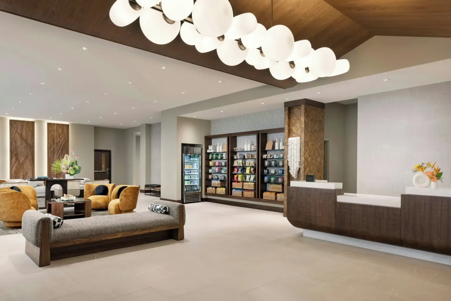 Lobby reception area with seating, market shelves, and globe pendant lights at AC Hotel Honolulu.