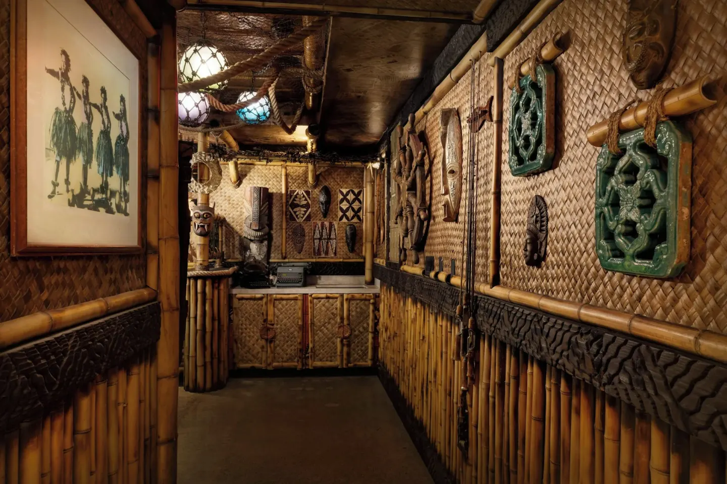 Bamboo-lined themed hallway with carved wall art at AC Hotel Honolulu.