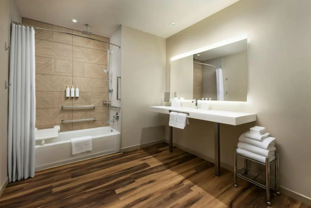City View bathroom with tub, lit mirror, vanity, and towels at AC Hotel Honolulu.