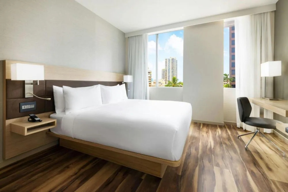 City View king guest room with desk and large windows at AC Hotel Honolulu.