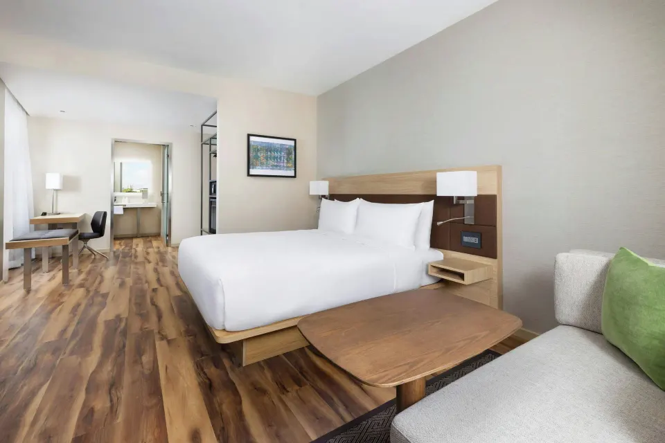 City View king room with desk, sofa, and open bathroom area at AC Hotel Honolulu.
