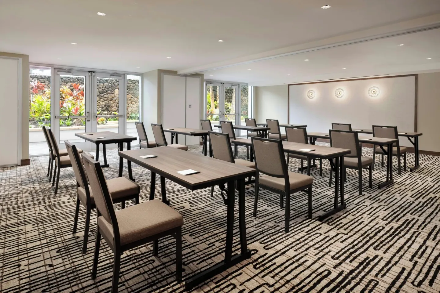 Meeting room with classroom tables and garden-facing windows at AC Hotel Honolulu.