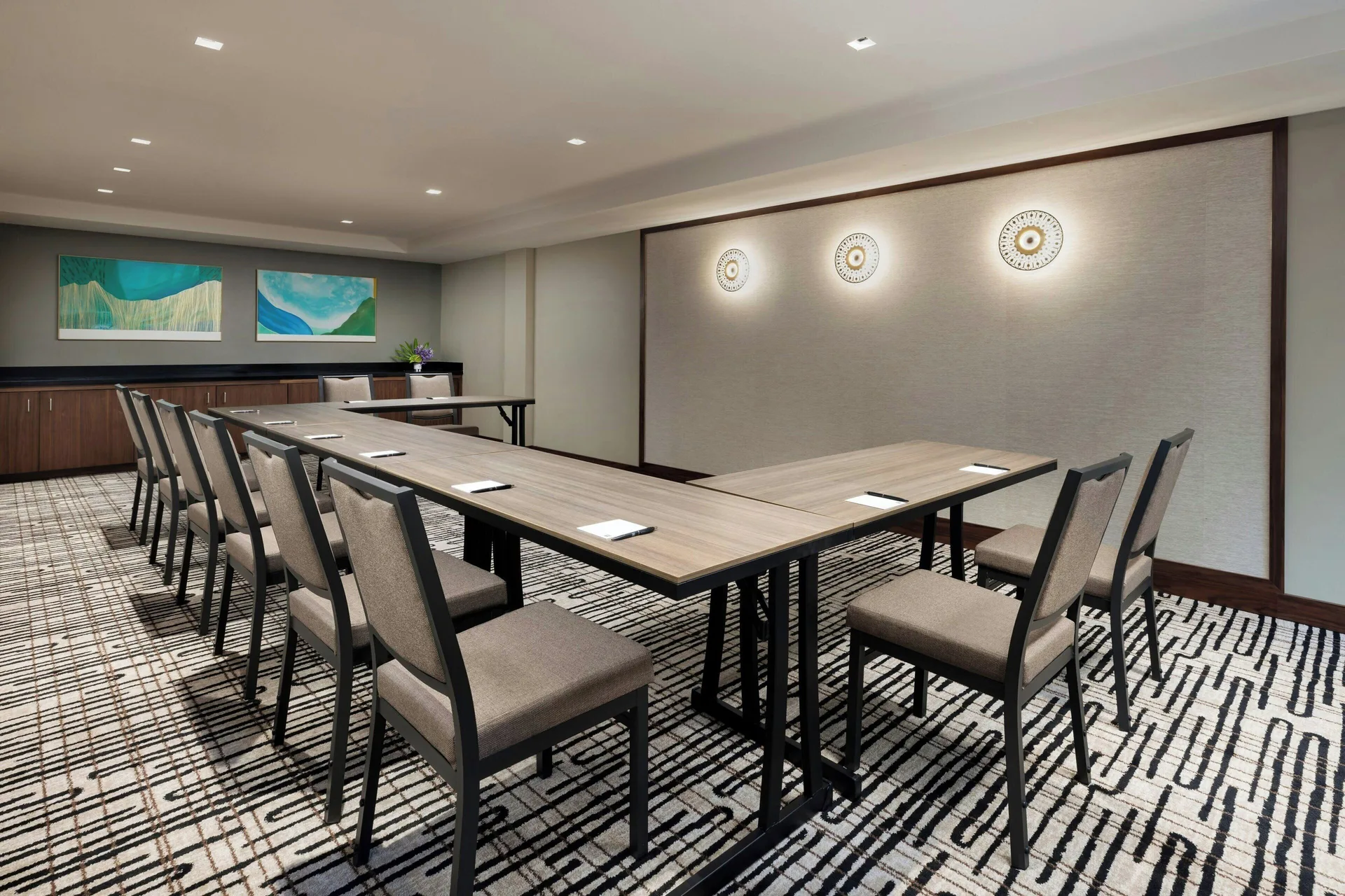 Conference room with U-shaped tables and wall art at AC Hotel Honolulu.