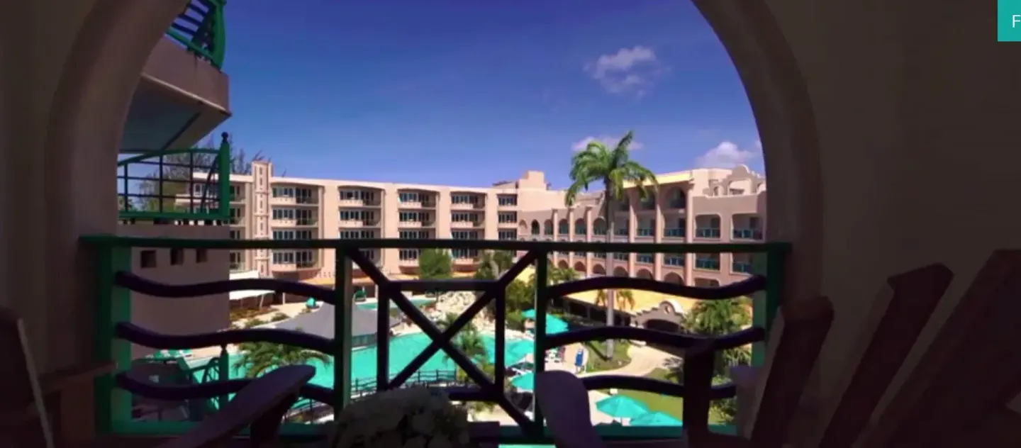 Balcony view through an arch toward the pool courtyard at Accra Beach Hotel & Spa.
