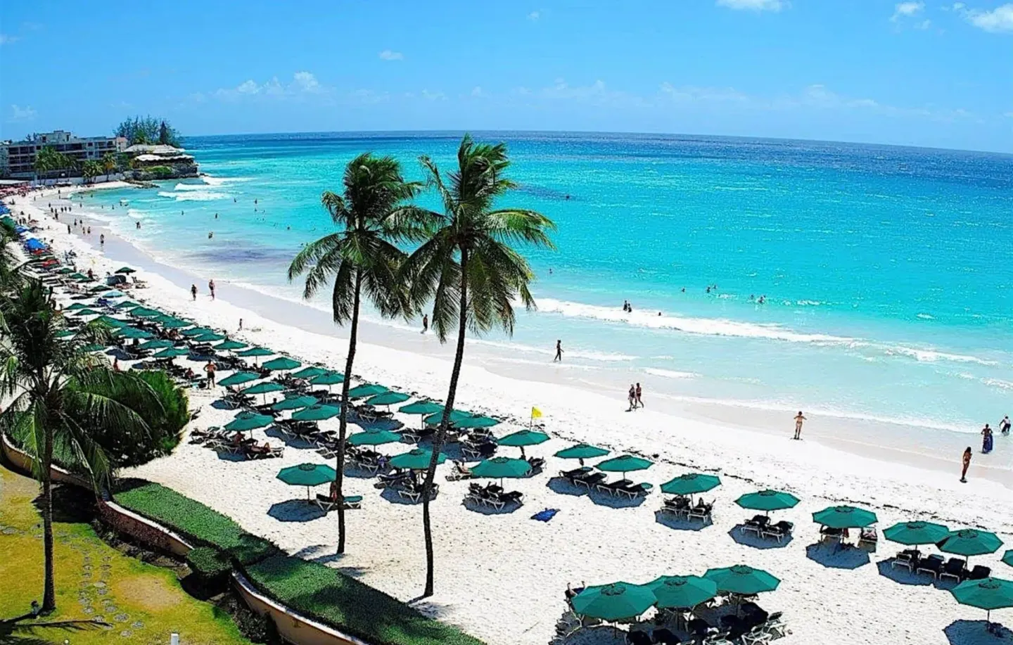 White-sand beach with teal umbrellas and turquoise sea at Accra Beach Hotel & Spa.