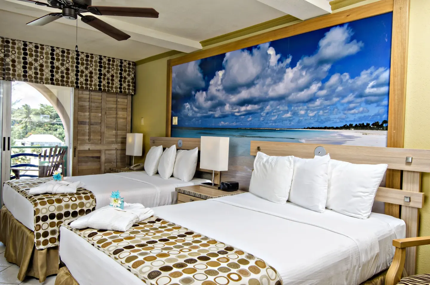 Guest room with two double beds and a beach mural at Accra Beach Hotel & Spa.