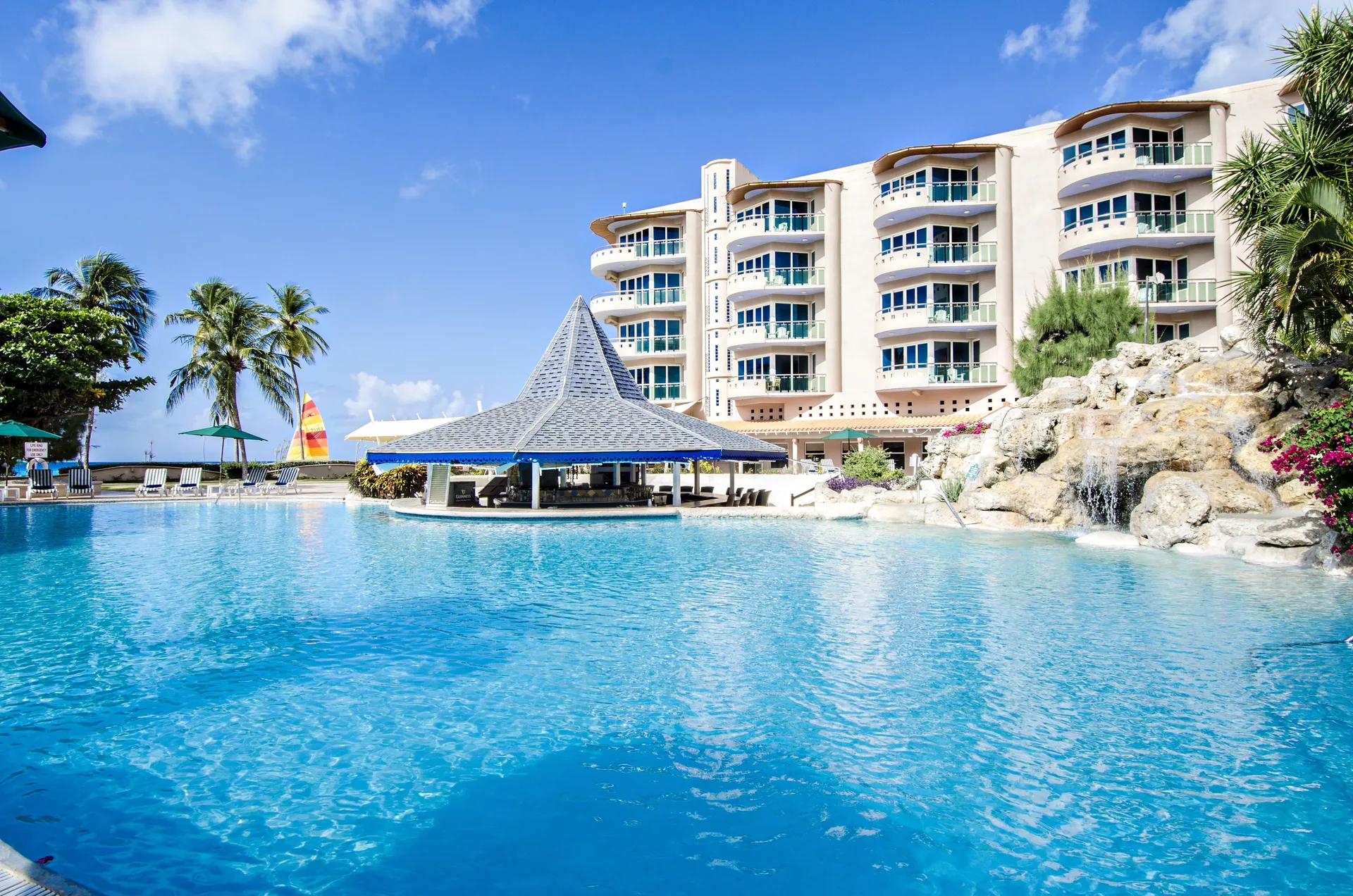 Large resort pool with pavilion, waterfall and hotel building at Accra Beach Hotel & Spa.