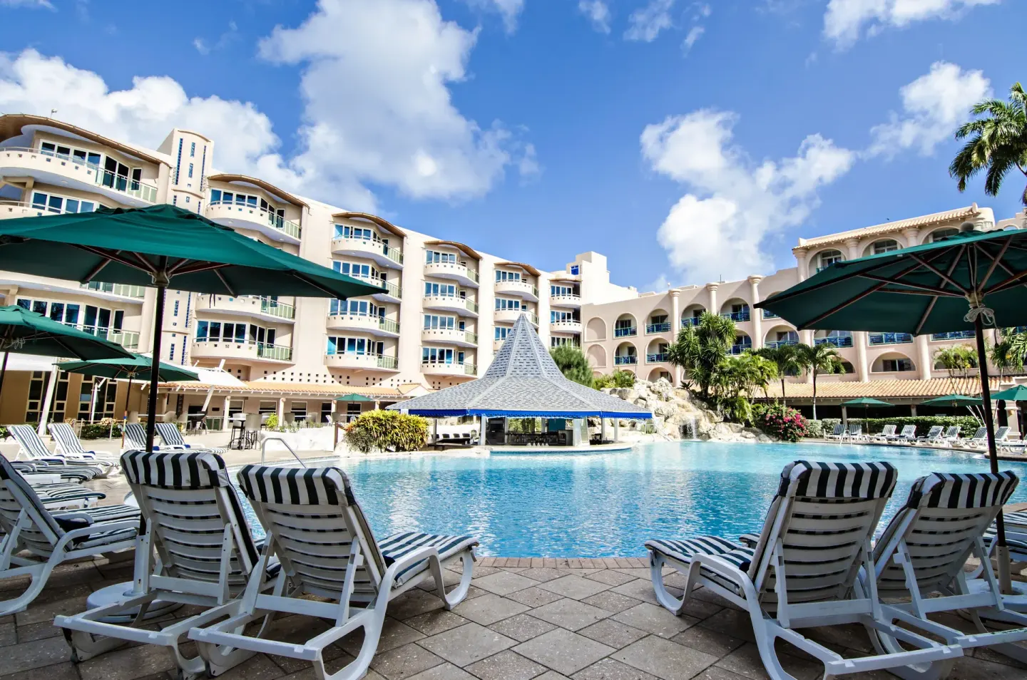 Pool deck with lounge chairs, umbrellas, and resort buildings at Accra Beach Hotel & Spa.