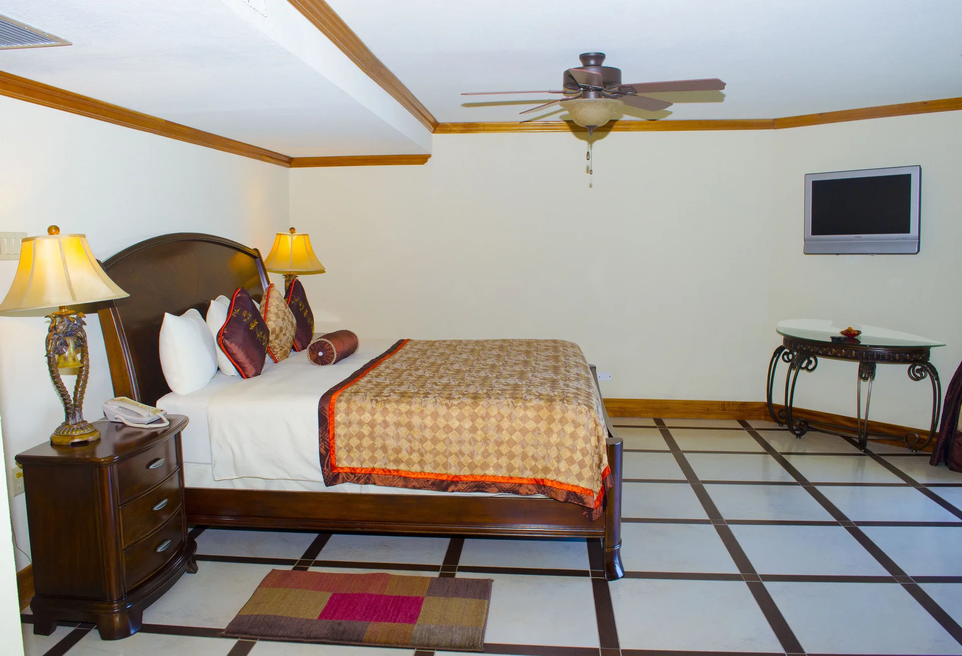 Deluxe Junior Suite bed and wall-mounted TV at Accra Beach Hotel & Spa.