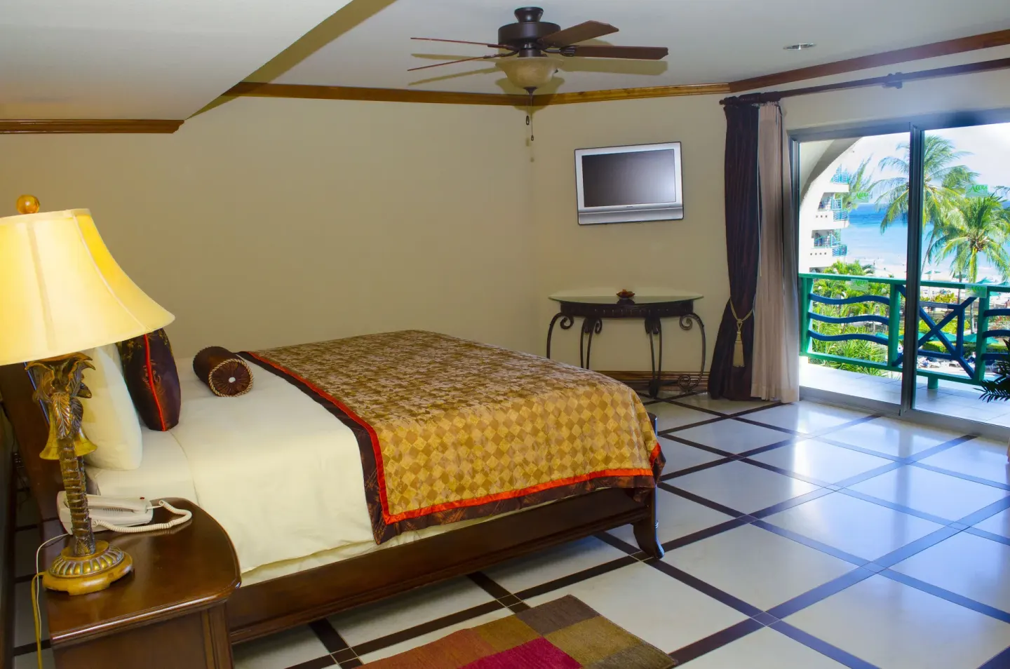 Deluxe Junior Suite king bed and balcony doors at Accra Beach Hotel & Spa.