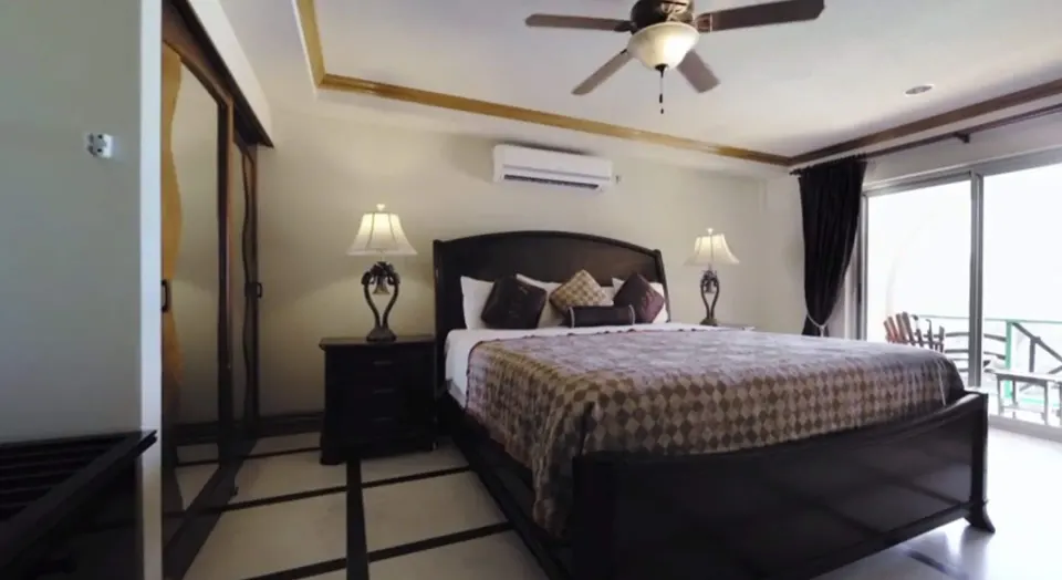Deluxe Junior Suite king bed with balcony beyond at Accra Beach Hotel & Spa.