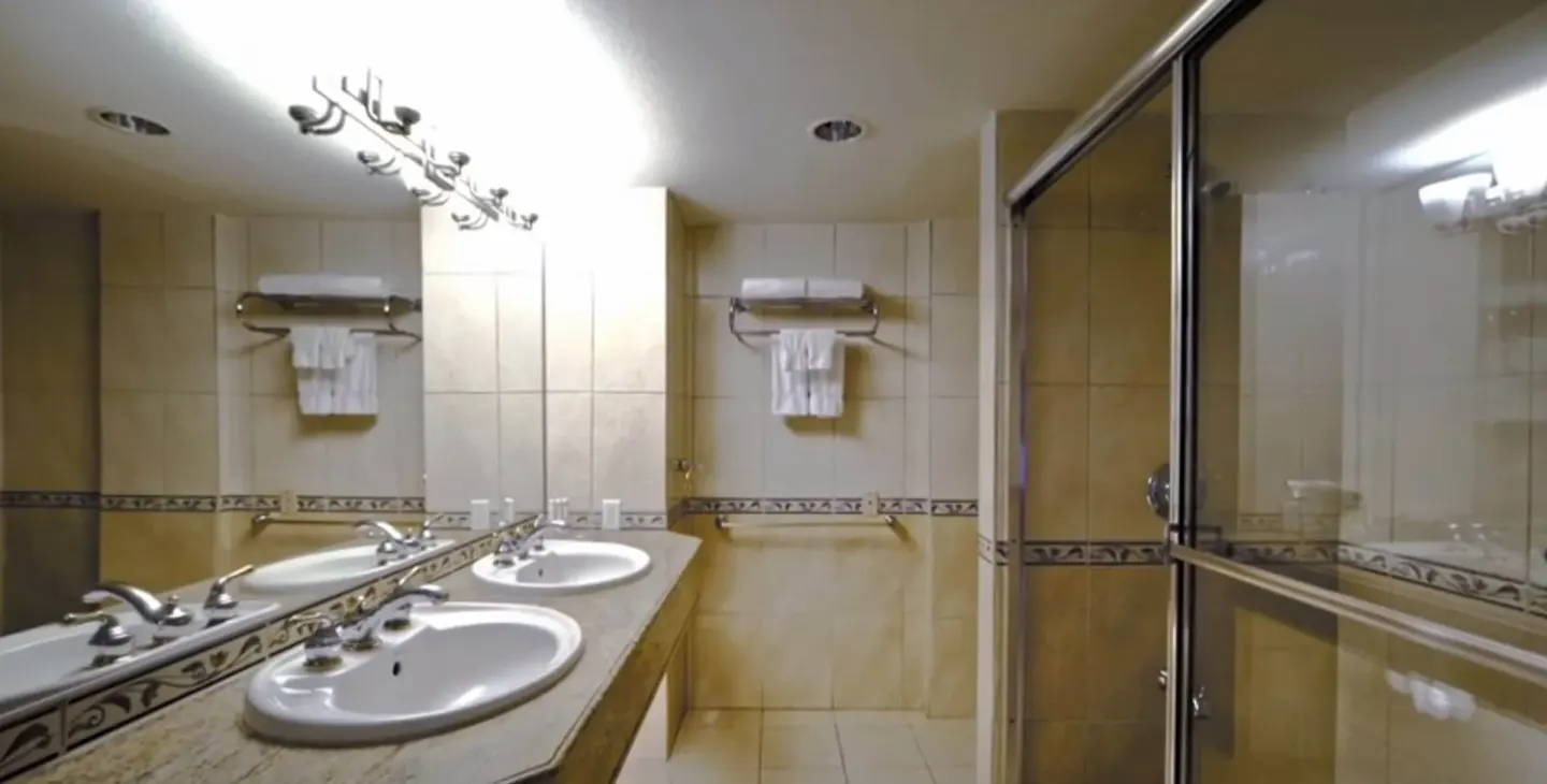 Junior Suite Island View bathroom with double vanity and glass shower at Accra Beach Hotel & Spa.