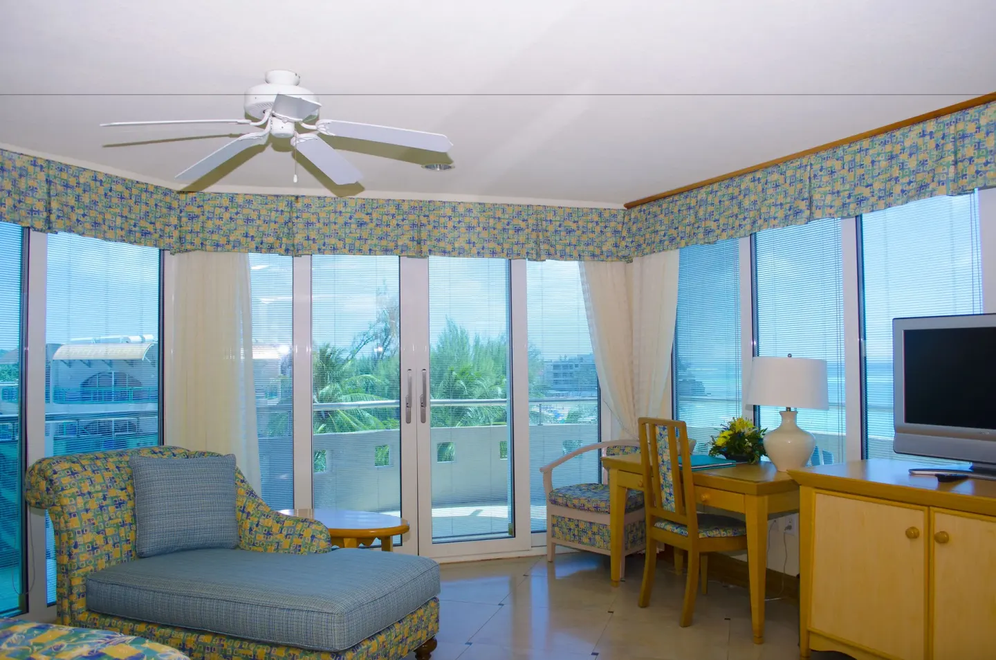 Living area in a Luxury Oceanfront Suite at Accra Beach Hotel & Spa with balcony doors and desk.