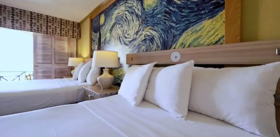 Pool View Room beds and wall mural near balcony at Accra Beach Hotel & Spa.