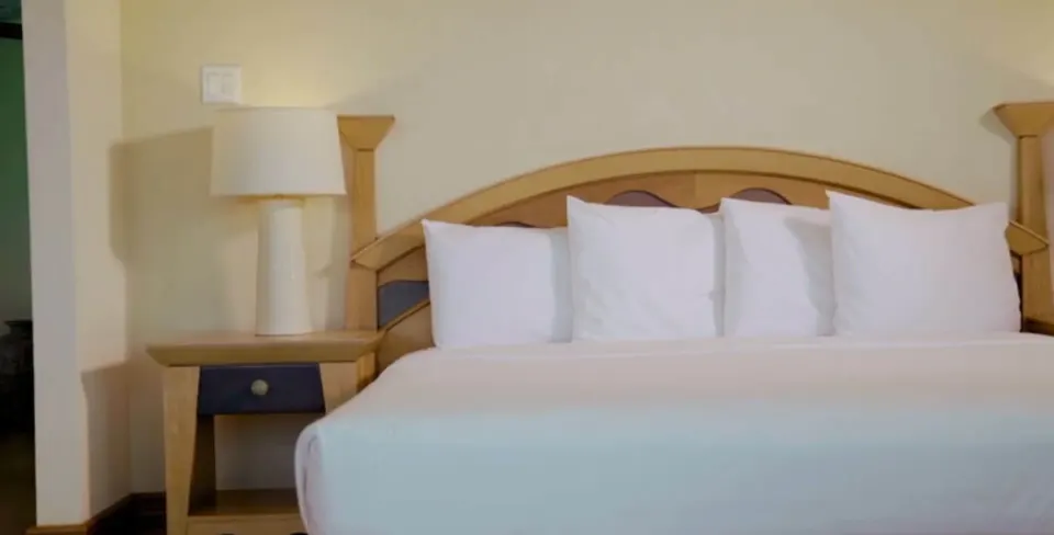 Ocean View room bed with white pillows and bedside lamp at Accra Beach Hotel & Spa.