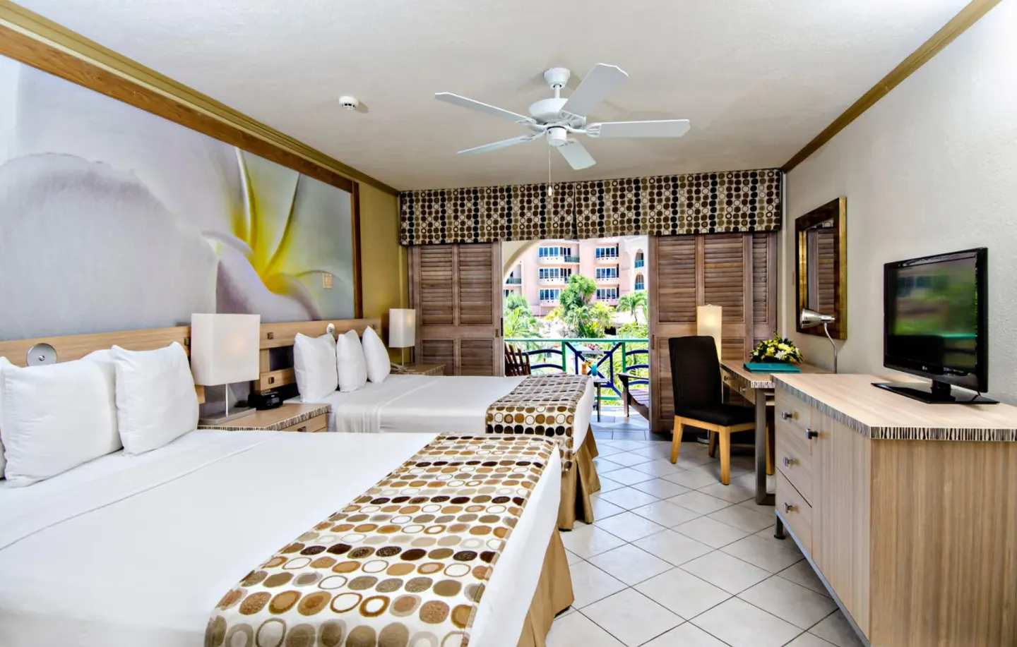 Ocean View room with two beds, desk, TV, and balcony at Accra Beach Hotel & Spa.