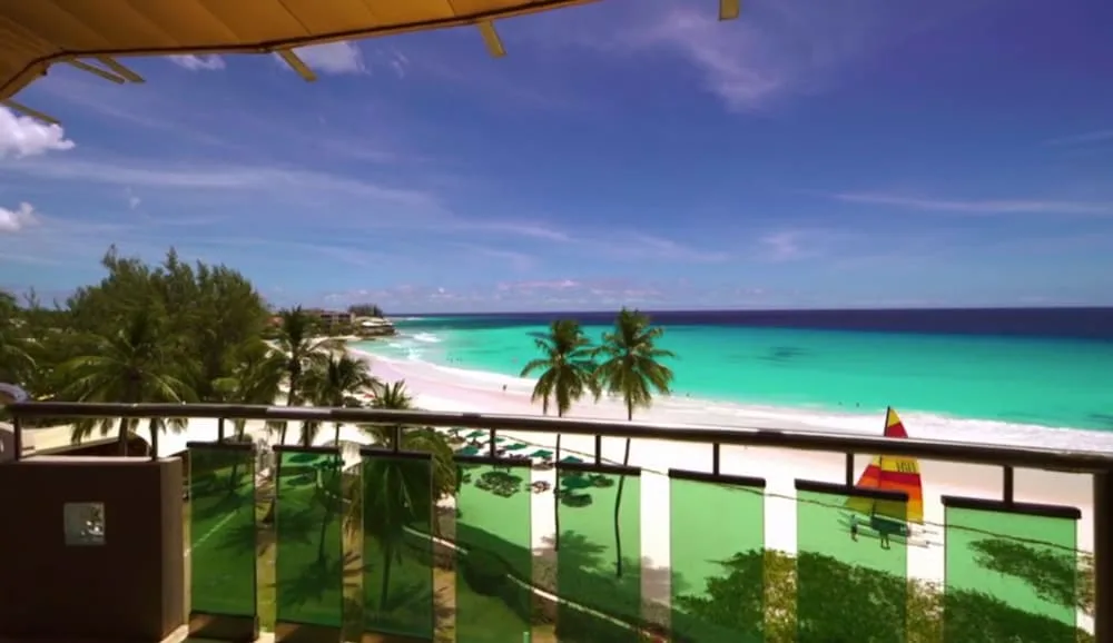 Balcony view of beach, palms, and turquoise sea at Accra Beach Hotel & Spa.