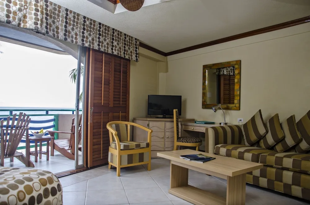 Oceanfront room sitting area with sofa bed and balcony at Accra Beach Hotel & Spa.