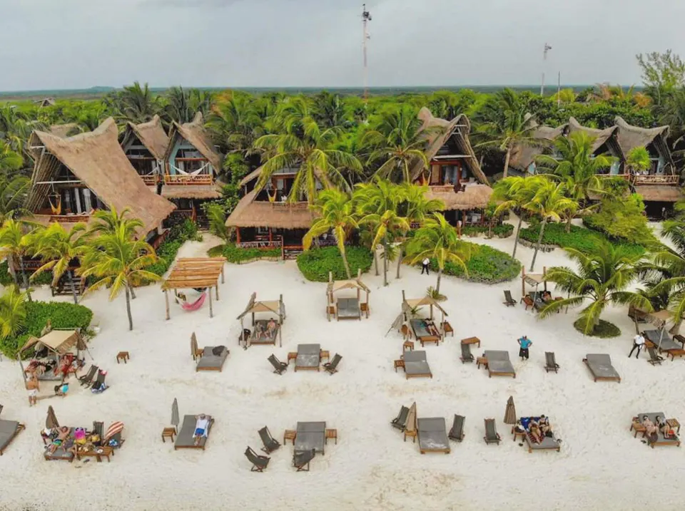 Aerial view of resort beachfront cabanas and sunbeds on the sand at Ahau Tulum