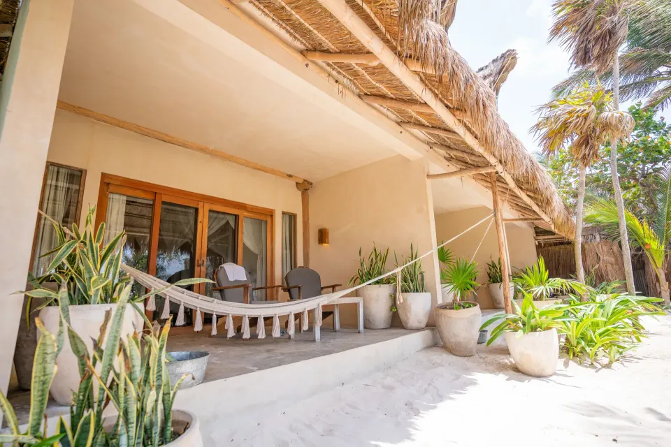 Private beachfront patio with hammock and chairs at Ahau Tulum