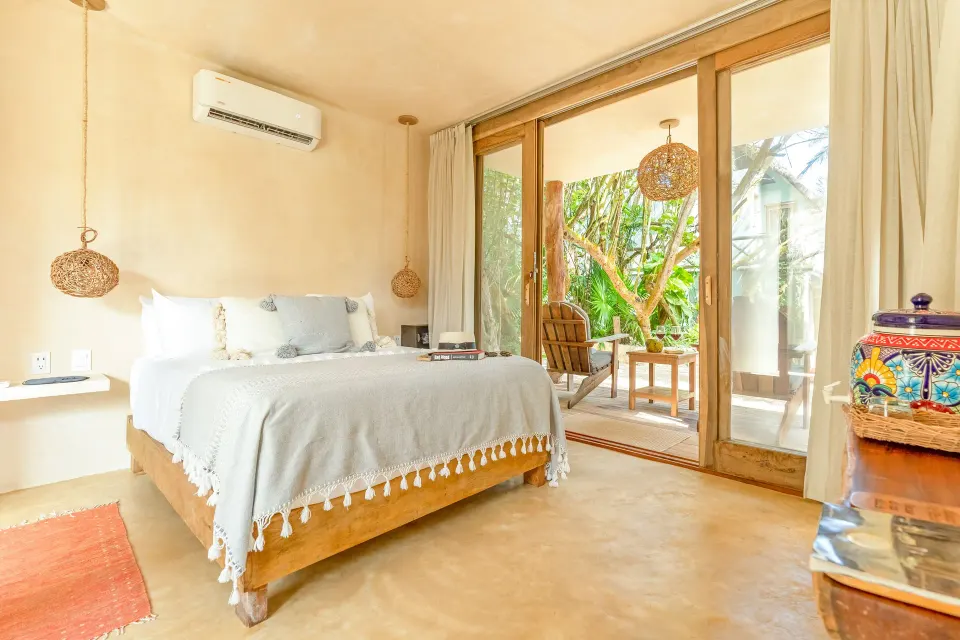 Bright ground‑level guest room with king bed and private terrace at Ahau Tulum