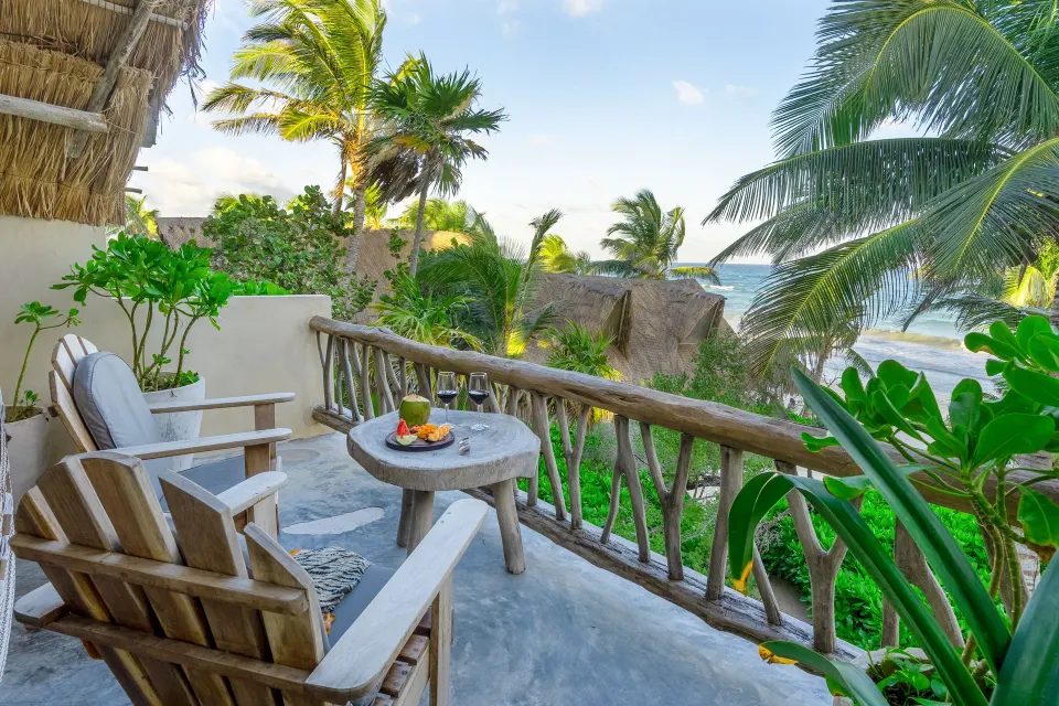 Balcony view over thatched rooftops to the Caribbean Sea at Ahau Tulum