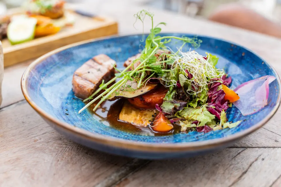 Plated salad with seared tuna on a blue dish at Ahau Tulum