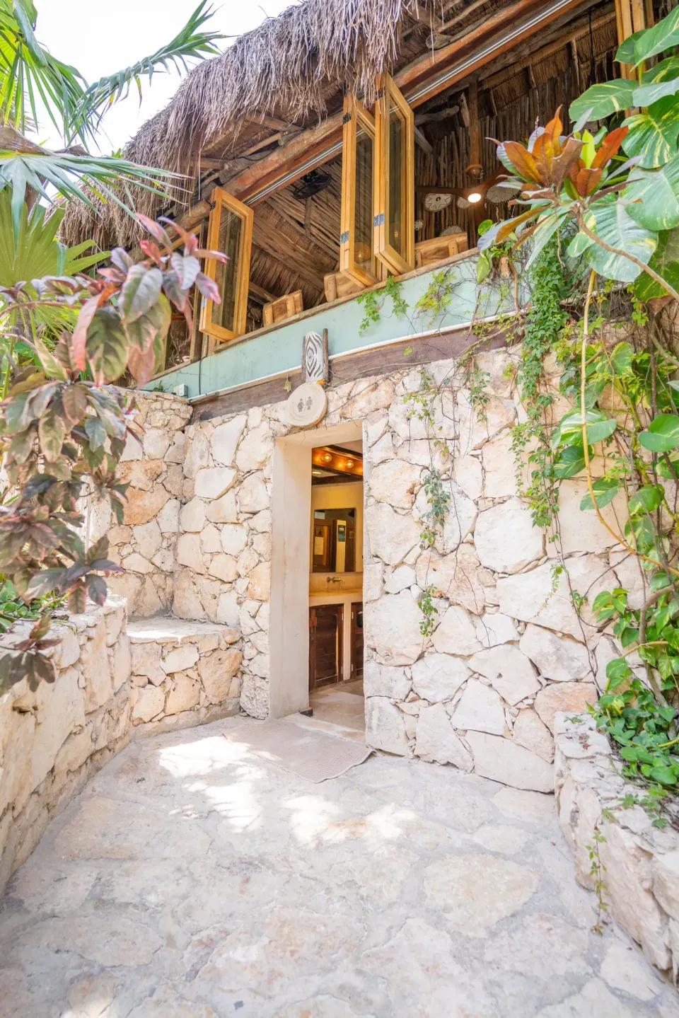 Stone entrance to a palapa dining area at Ahau Tulum