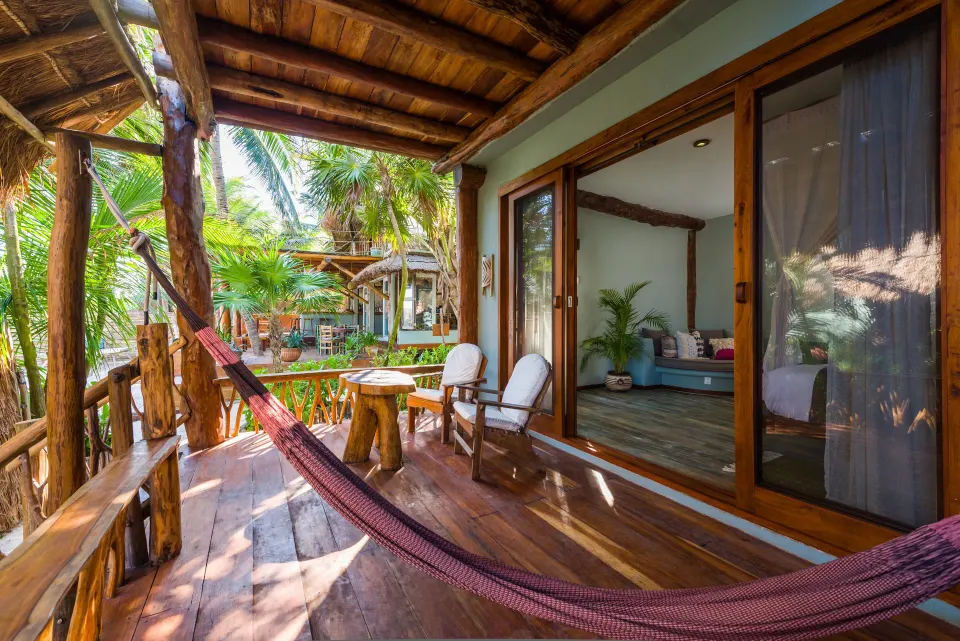 Wooden balcony with hammock and garden view outside Junior Suite at Ahau Tulum
