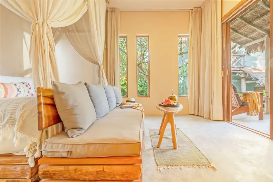Front view of the canopy bed and daybed with sliding doors to the terrace at Ahau Tulum