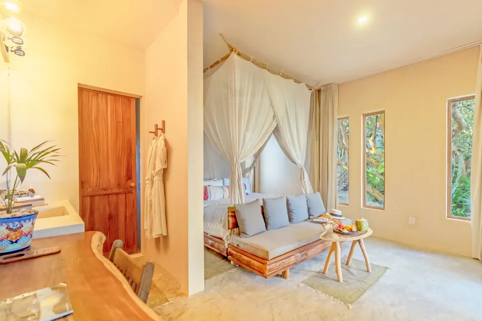 Junior suite interior with canopy bed and seating area at Ahau Tulum