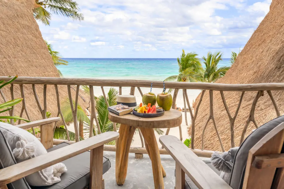 Small balcony seating with tropical fruit and ocean view at Ahau Tulum