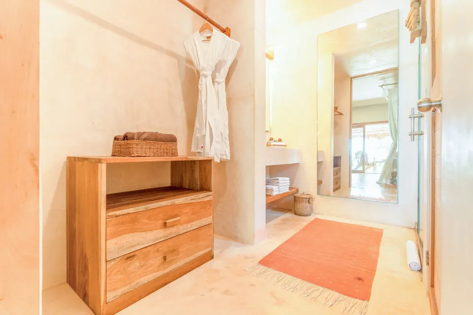 Junior Suite Oceanfront Beach level bathroom dressing area at Ahau Tulum with robe and wooden storage