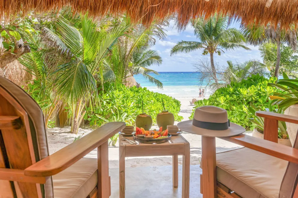 Beachfront view from a Junior Suite Oceanfront Beach level patio at Ahau Tulum with chairs and ocean beyond